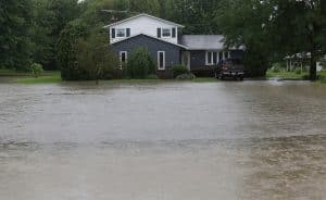 10july13 bishop---A home stands dry as rising waters on Rt 303 work closer and closer to the house. Many homes in that area were in danger of flooding